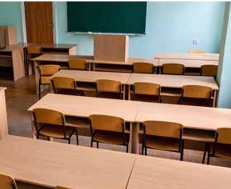 Empty classroom with rows of wooden desks and chairs
